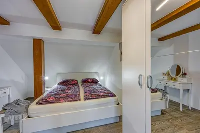 a white bedroom with a bed and a mirror at Kolpa reka 