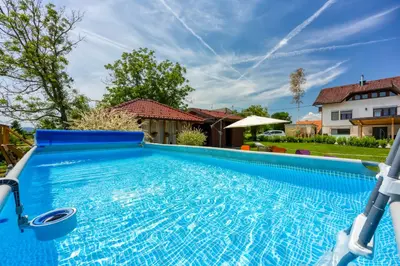 a large blue swimming pool in front of a house at Kolpa reka 