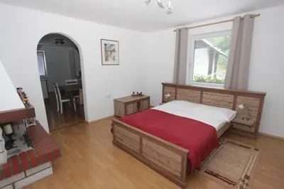 a bedroom with a bed and a window and a table at Apartments Ela in Rateče