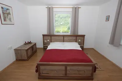 a bedroom with a wooden bed and a window at Apartments Ela in Rateče