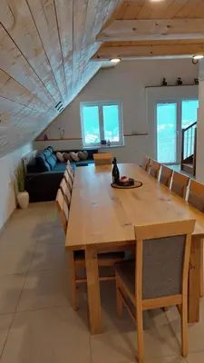 a dining room with a wooden table and chairs at Apartments Ela in Rateče