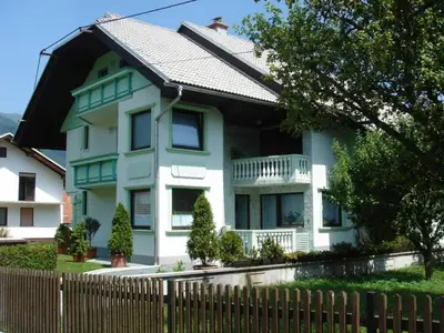 a blue and white house with a fence at The Green House in Mojstrana