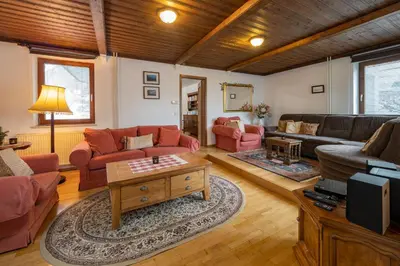 a living room with couches and a table at The Green House in Mojstrana