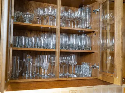a bunch of glasses on shelves in a cabinet at The Green House in Mojstrana