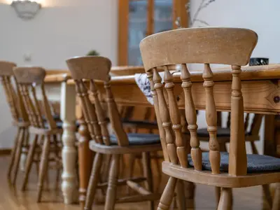 a group of wooden chairs around a wooden table at The Green House in Mojstrana