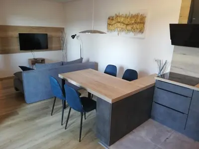 a living room with a table and a blue couch at Apartment Leggero in Moravske Toplice