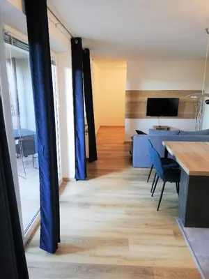 a living room with blue curtains and a table at Apartment Leggero in Moravske Toplice