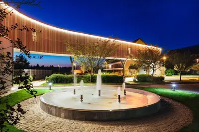a fountain in front of a building at night at Apartment Leggero in Moravske Toplice