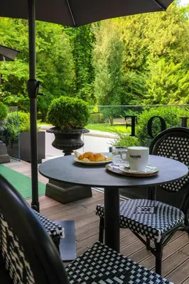 a table with a plate of food and an umbrella at Boutique Hotel Dobrna - Terme Dobrna in Dobrna