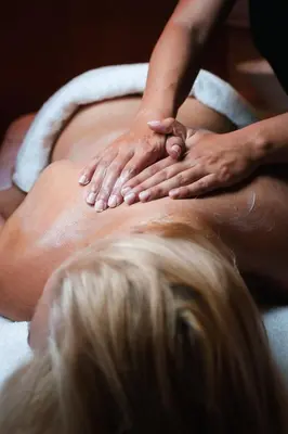 a woman getting a back massage in a towel at Boutique Hotel Dobrna - Terme Dobrna in Dobrna