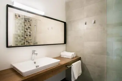 a bathroom with a sink and a mirror at Roko Garni Hotel in Brezovica