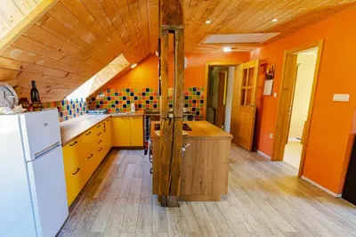 a kitchen with orange walls and a wooden ceiling at Apartment Vrhivšek in Frankolovo