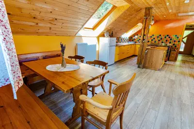 a kitchen and dining room with a wooden table and chairs at Apartment Vrhivšek in Frankolovo