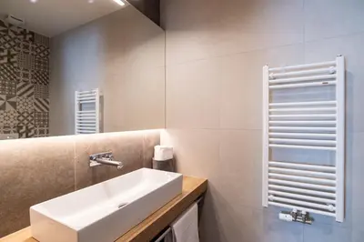 a white bathroom with a sink and a mirror at Penzion Repanšek in Radomlje