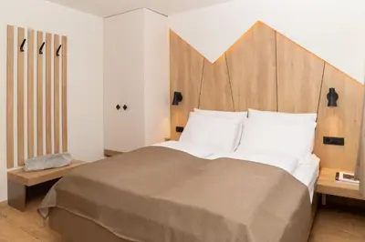 a bedroom with a large bed with a wooden headboard at Penzion Repanšek in Radomlje