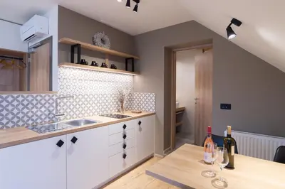 a kitchen with a sink and a counter with wine bottles at Penzion Repanšek in Radomlje