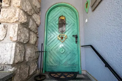 a turquoise door with a heart on it at Apartmaji Rauter in Bohinj