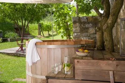 a wooden hot tub with a bowl of fruit on a table at Villa Artes with Free Hot Tub & Sauna in Branik