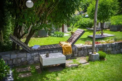 a garden with a bench and a table in the grass at Villa Artes with Free Hot Tub & Sauna in Branik
