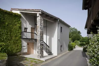 a white house with a spiral staircase in a driveway at Villa Artes with Free Hot Tub & Sauna in Branik