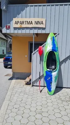 a green and blue kayak sitting outside of a building at Apartma Nina in Bohinj