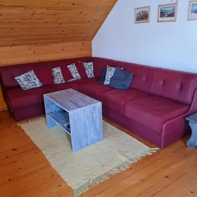 a living room with a red couch and a table at Apartma Nina in Bohinj