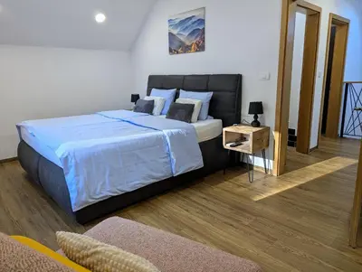 a bedroom with a large bed with blue sheets and pillows at MY TIME BLED Holiday House with sauna in Zgornje Gorje