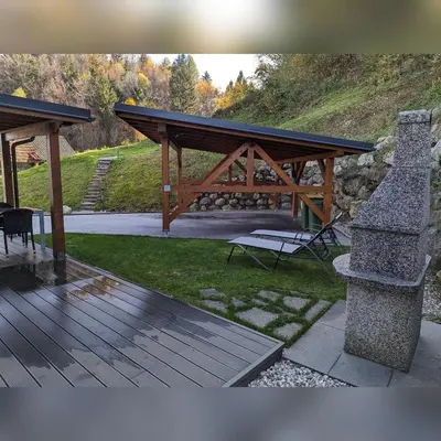 a picnic shelter with a bench and a table at MY TIME BLED Holiday House with sauna in Zgornje Gorje