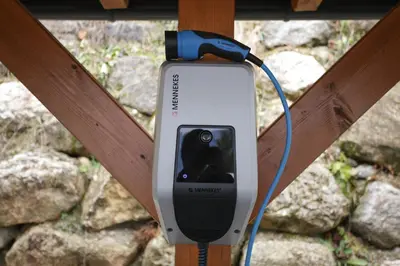 a cell phone is hooked up to a wooden pole at MY TIME BLED Holiday House with sauna in Zgornje Gorje