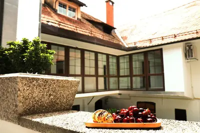 a plate of fruit on a table in front of a house at Petkovšek Rooms and Apartments in Ljubljana