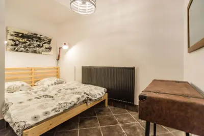 a bedroom with a bed and a suitcase in it at Apartma N'Poznam in Ljubljana