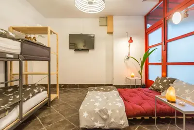 a living room with a couch and bunk beds at Apartma N'Poznam in Ljubljana