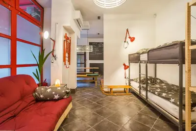 a room with bunk beds and a red couch at Apartma N'Poznam in Ljubljana