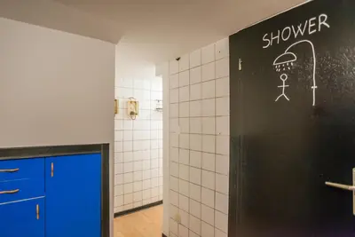 a bathroom with a shower sign on the wall at Apartma N'Poznam in Ljubljana