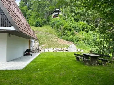 a picnic table and bench in a yard at Our Forest House in Tržič