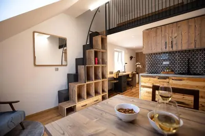 a room with a table with a glass of wine at Becycle Sustainable stay and travel in Maribor