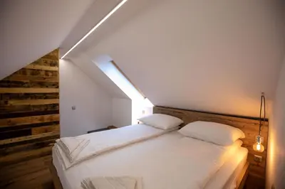 a bedroom with a white bed in a attic at Becycle Sustainable stay and travel in Maribor