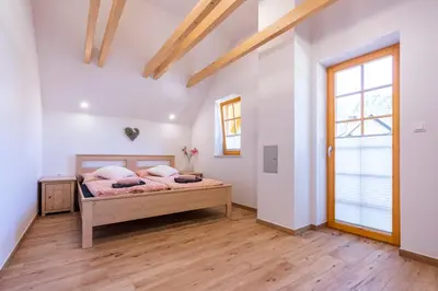 a bedroom with a bed and a wooden floor at Holiday house Zupanc in Bohinj