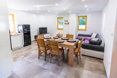 a dining room and living room with a table and chairs at Holiday house Zupanc in Bohinj