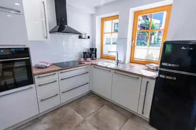 a kitchen with white cabinets and a black refrigerator at Holiday house Zupanc in Bohinj