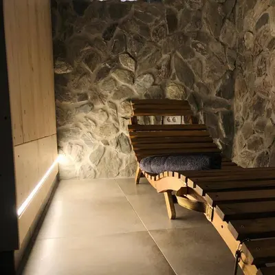 a bench in a room with a stone wall at Holiday house Zupanc in Bohinj