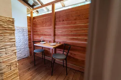 a small table and two chairs in a room with wooden walls at Savna cimr in Mežica