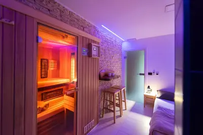 a room with a bedroom with a bed and a room with a table at Savna cimr in Mežica