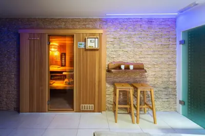 a kitchen with two stools and a brick wall at Savna cimr in Mežica