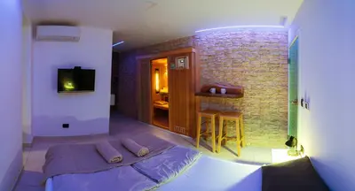 a room with a bed and a tv and a brick wall at Savna cimr in Mežica