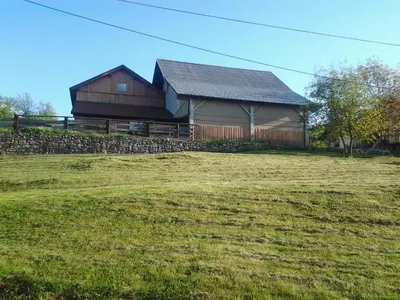 a large barn in a field next to a field at Eko kmetija Gerbec in Grahovo