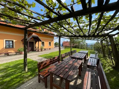 a group of wooden benches sitting under a pergola at House Donačka Gora in Rogatec