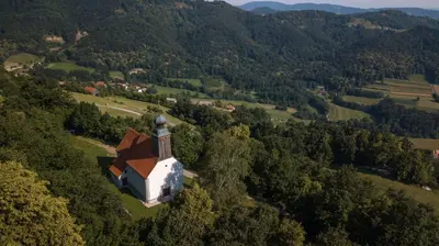 an aerial view of a small church in the forest at House Donačka Gora in Rogatec