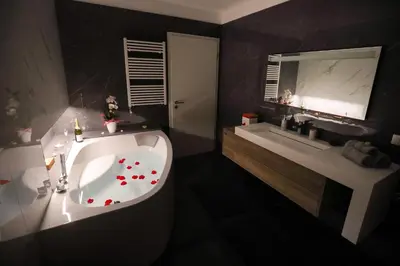 a bathroom with a tub and a sink and a mirror at Hisa dobrega pocutja in Kozina