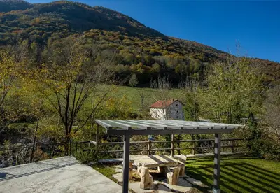 a picnic bench in front of a mountain at Apartments Jez in Slappe dʼIdria